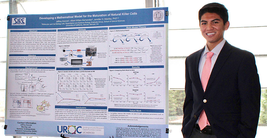 Jeffrey Aceves stands next to research poster