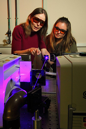 Professor Anne Myers Kelley, left, works with a student in her laser lab.