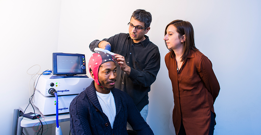 Students and faculty member testing brain-scanning device