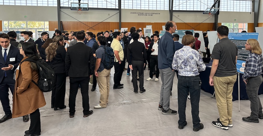 People are showing attending the I2G event and examining posters of projects.