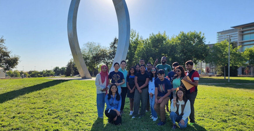 Photo depicts participants in the summer internship program in front of the Beginnings statue at UC Merced.