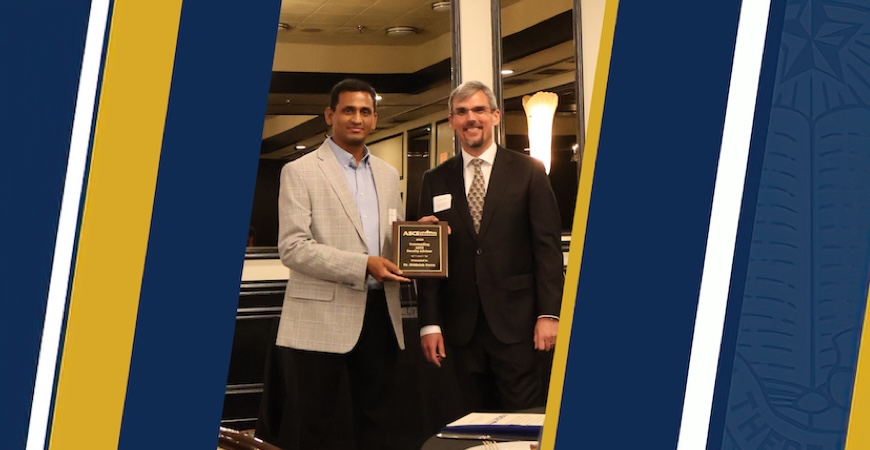 Photo depicts Professor Siddaiah Yarra accepting a plaque on a blue and gold graphic background.